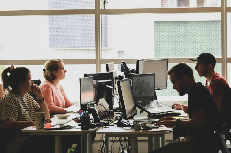 Grupo de pessoas trabalhando com tecnologia em um escritório.